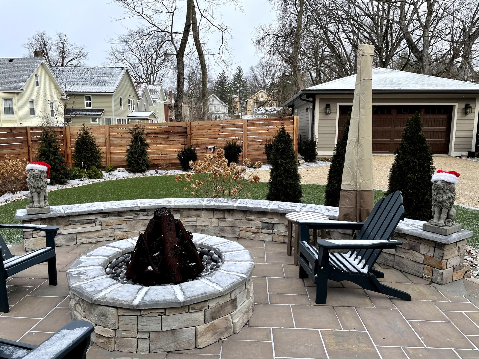 Circular stone fire pit with seating on a paver patio