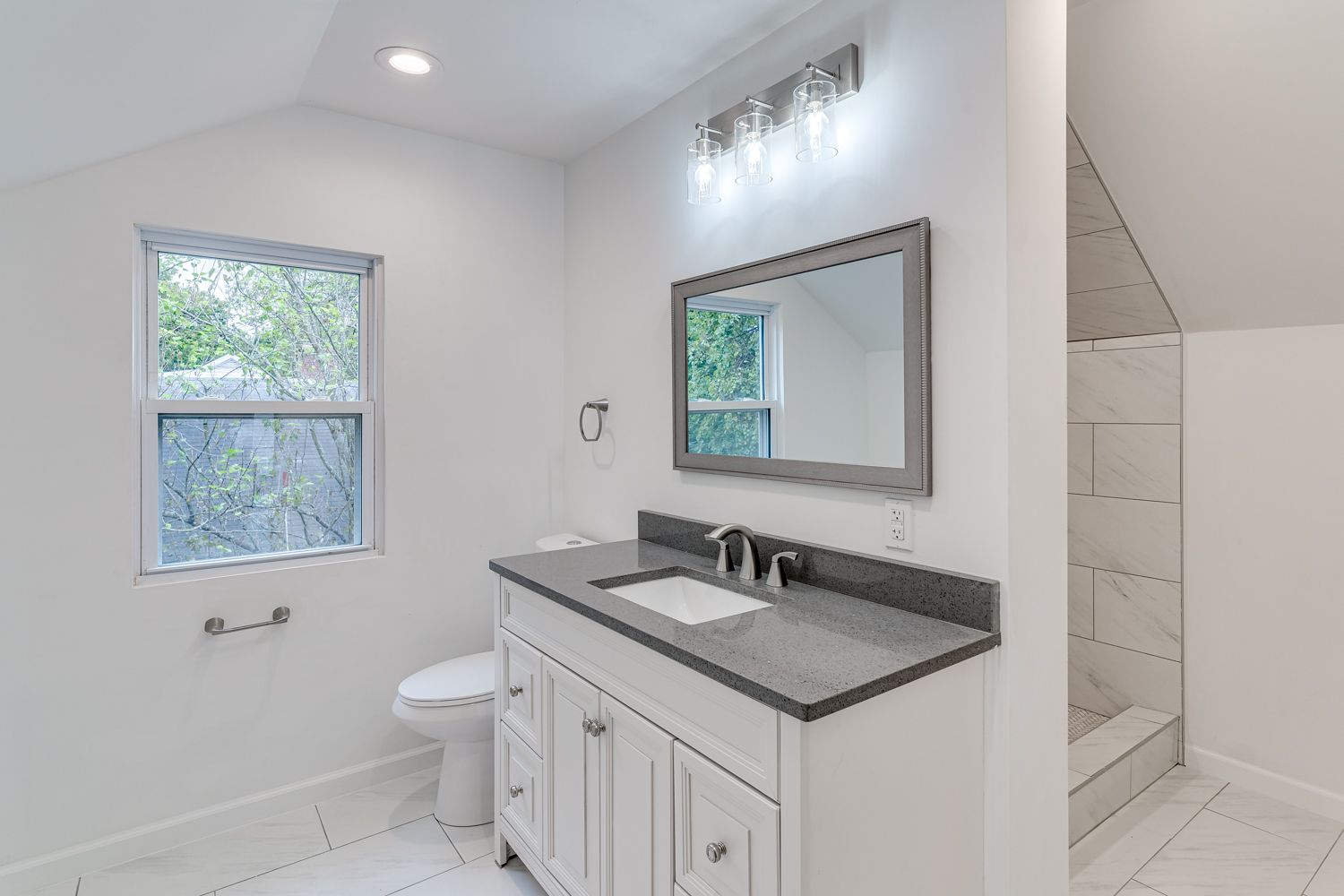 Updated bathroom with white vanity and dark countertop