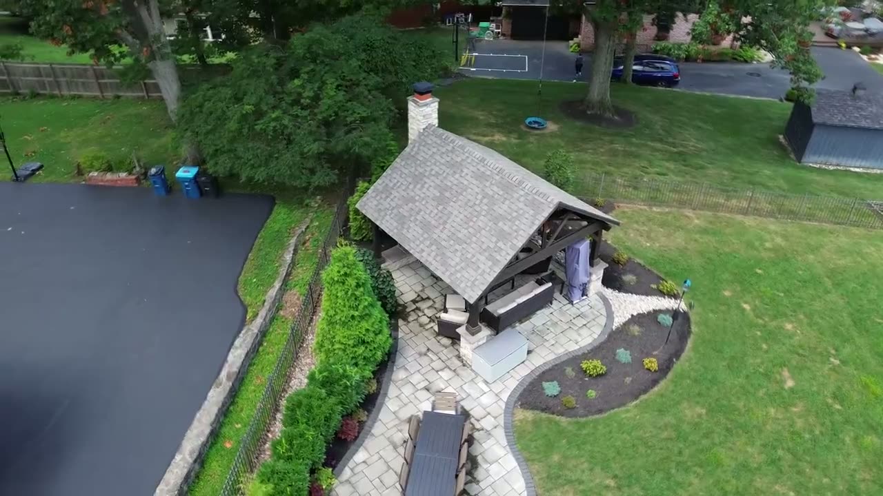 Drone flyover of a backyard pavilion and patio.