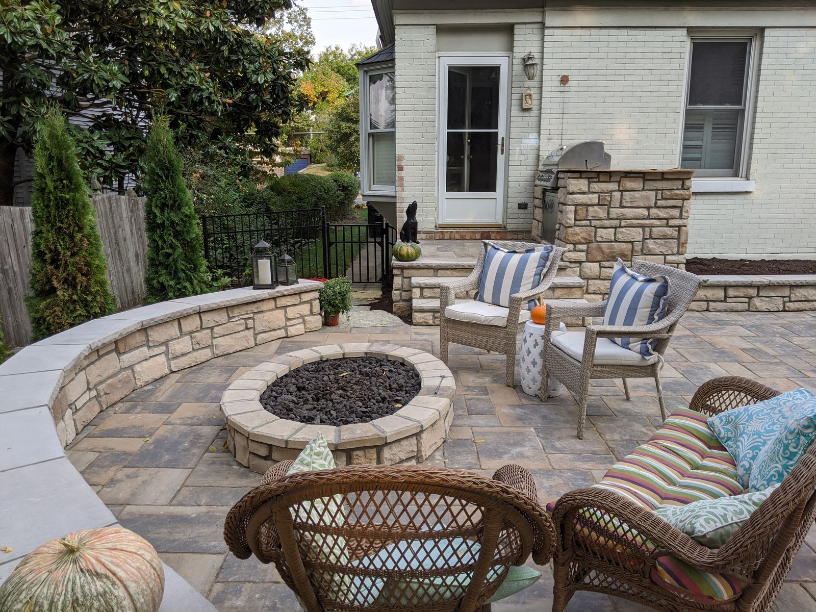 Round stone fire pit with a curved seat wall on a paver patio