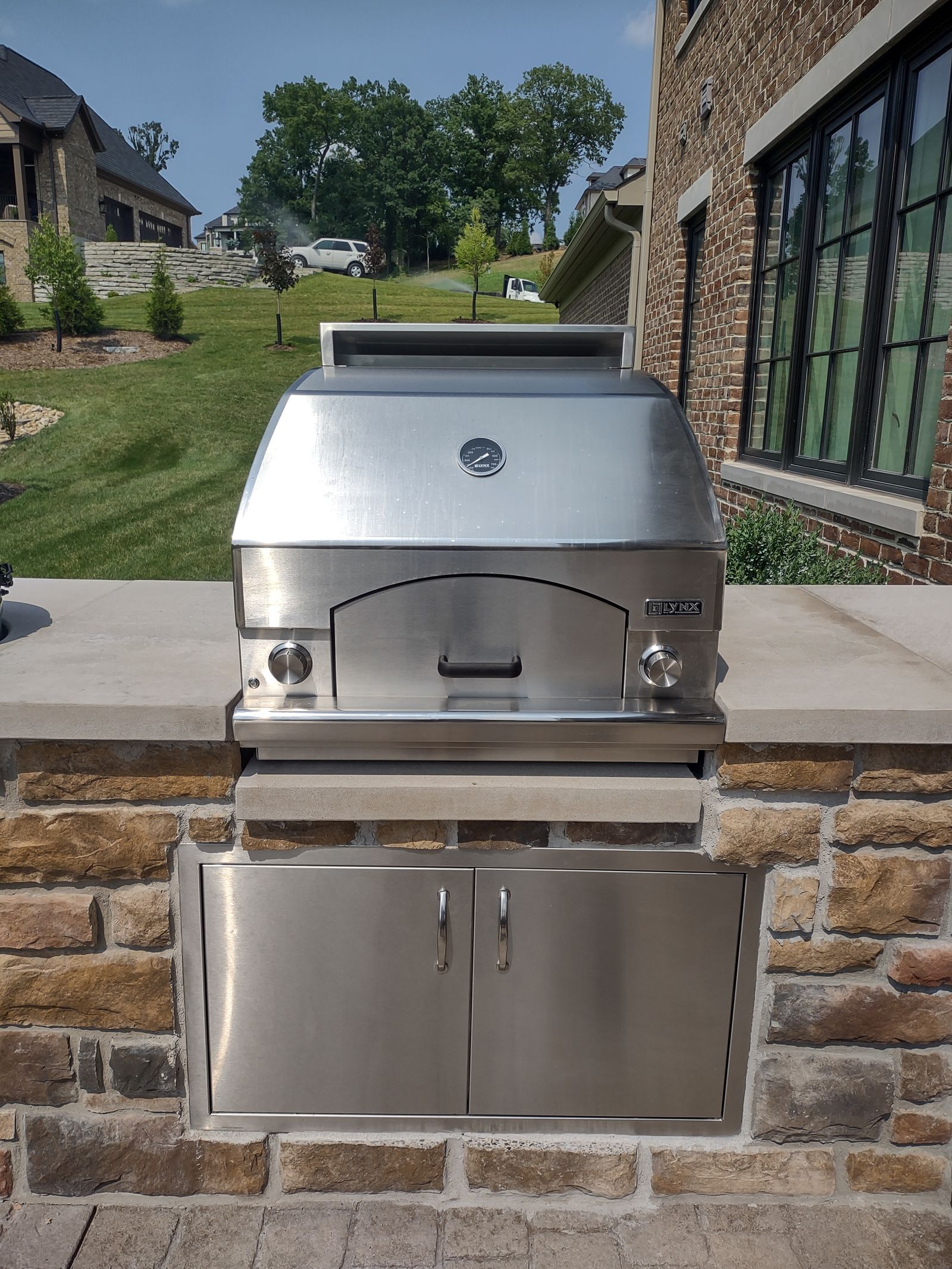 Stainless built-in grill set in a natural stone outdoor kitchen