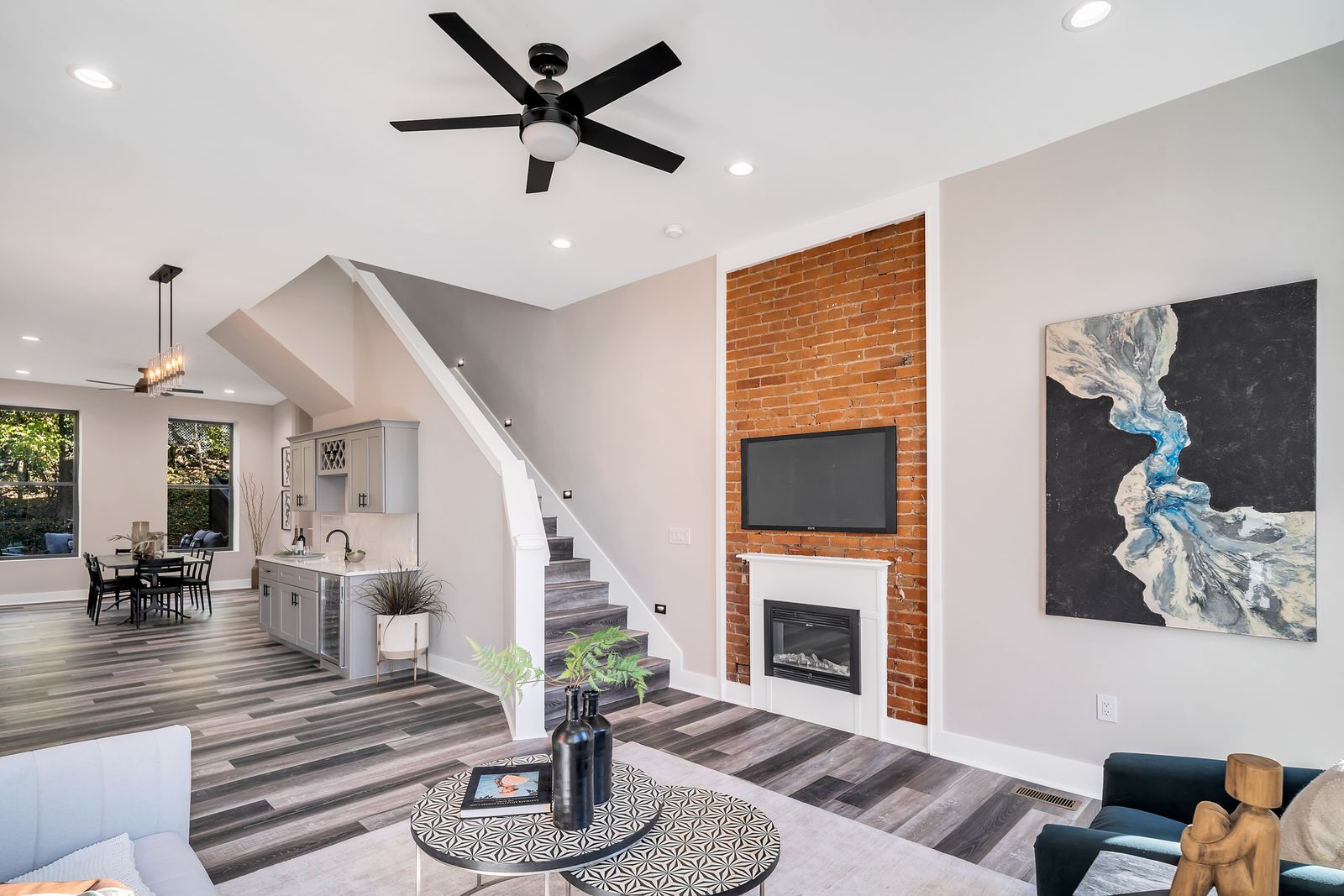 Living room with brick fireplace wall and staircase