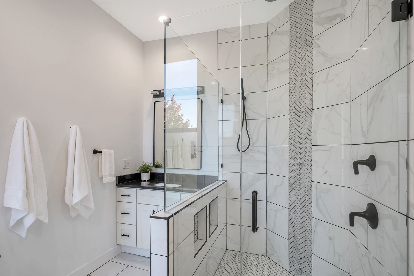 Renovated bathroom with walk-in shower and marble-look tile