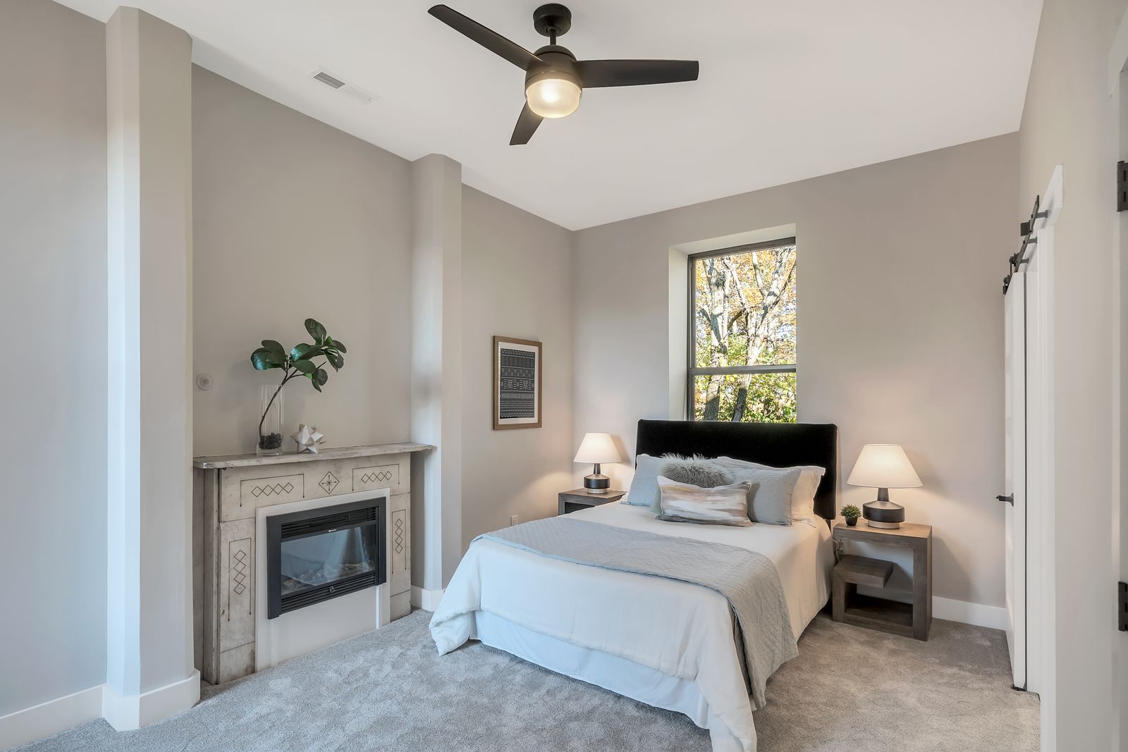 Bedroom with fireplace and garden-facing windows