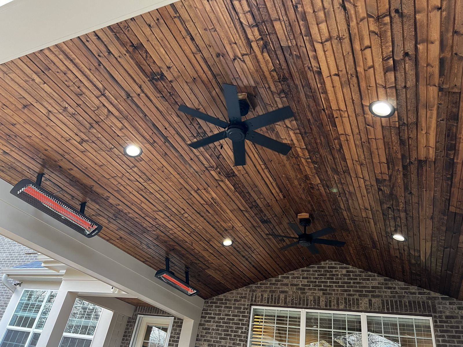 Vaulted wood porch ceiling with infrared heaters and ceiling fans