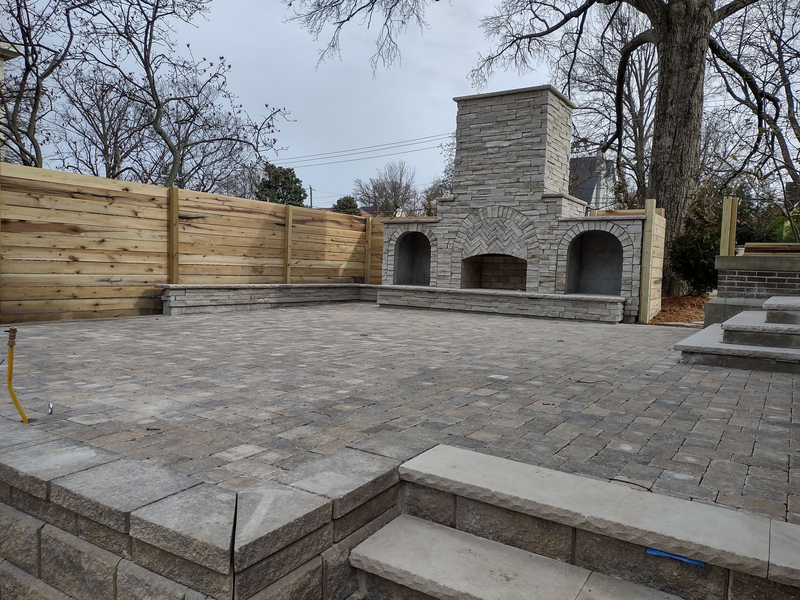 Stone steps and walls terracing a paver patio