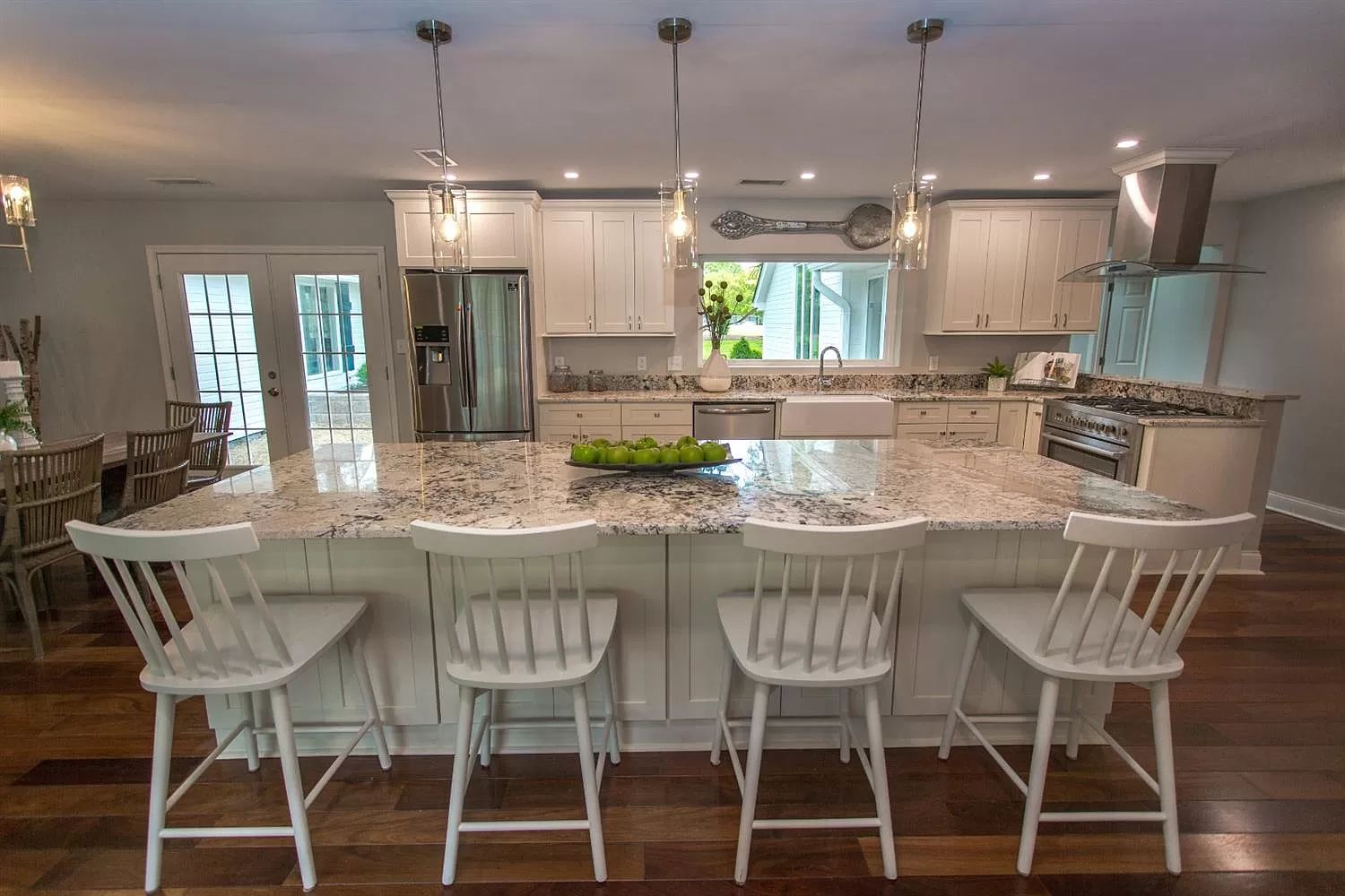 Kitchen with white cabinetry, island, and hardwood floors