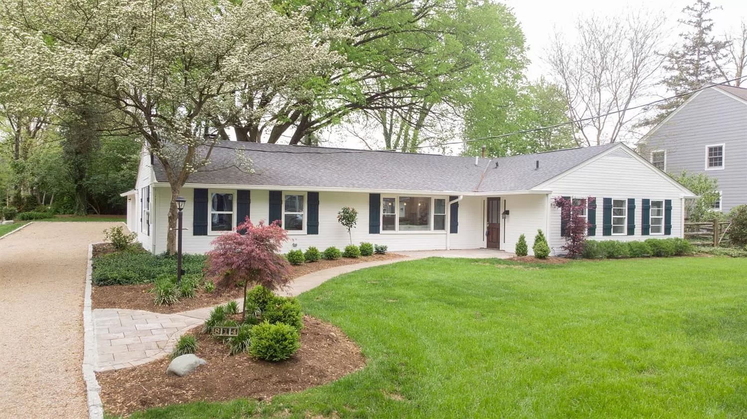 Ranch home exterior with lawn and mature trees