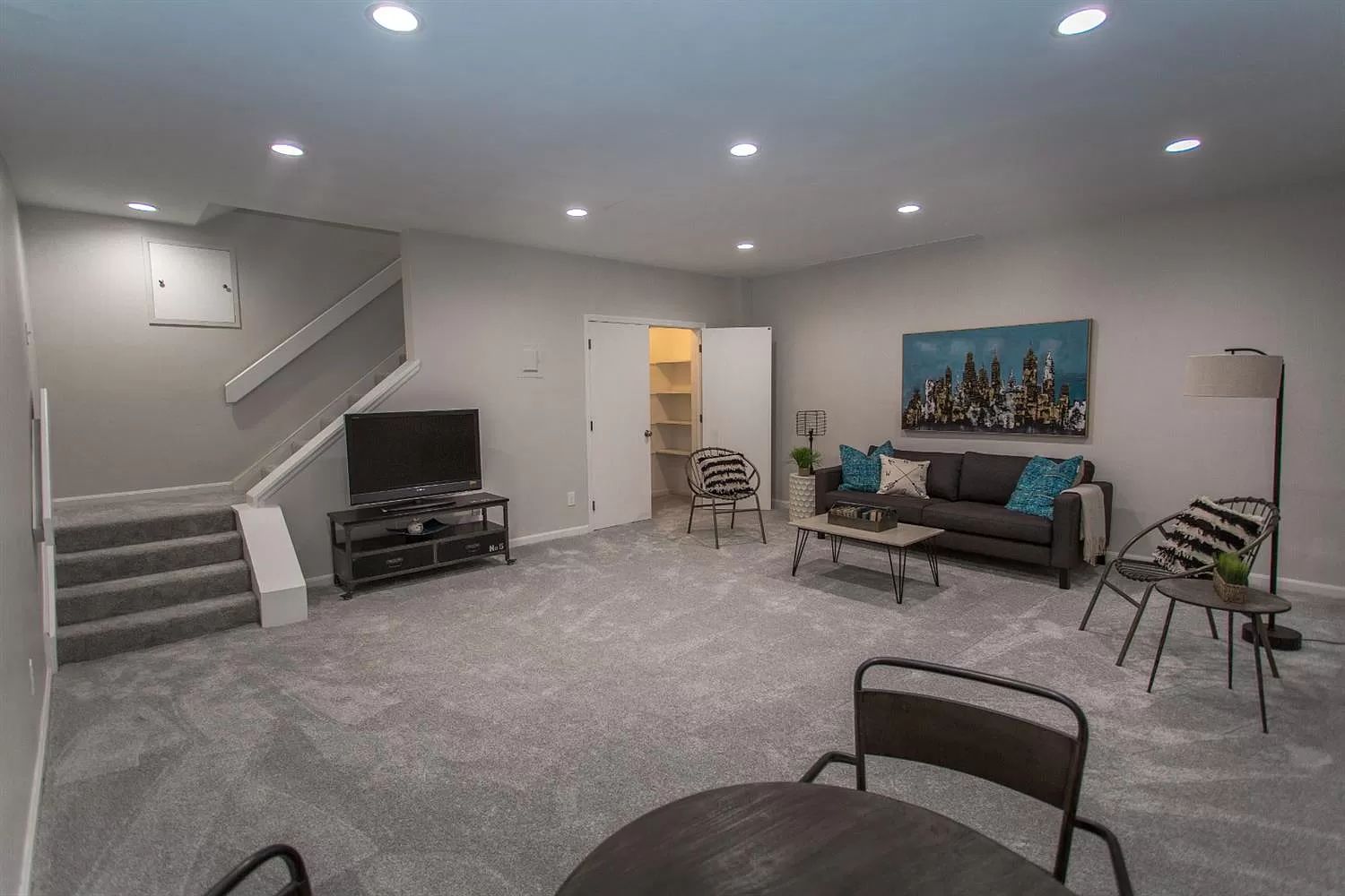 Finished lower-level rec room with lounge seating and media console