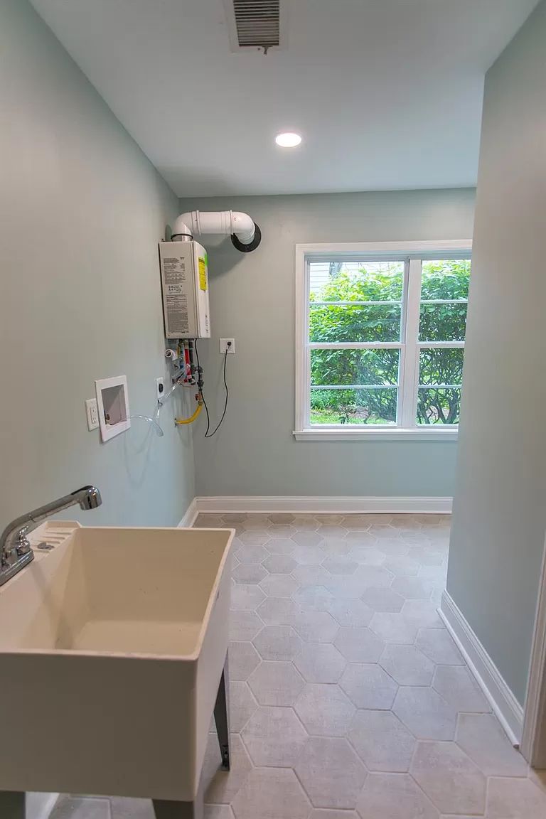 Bright laundry room with utility sink and storage