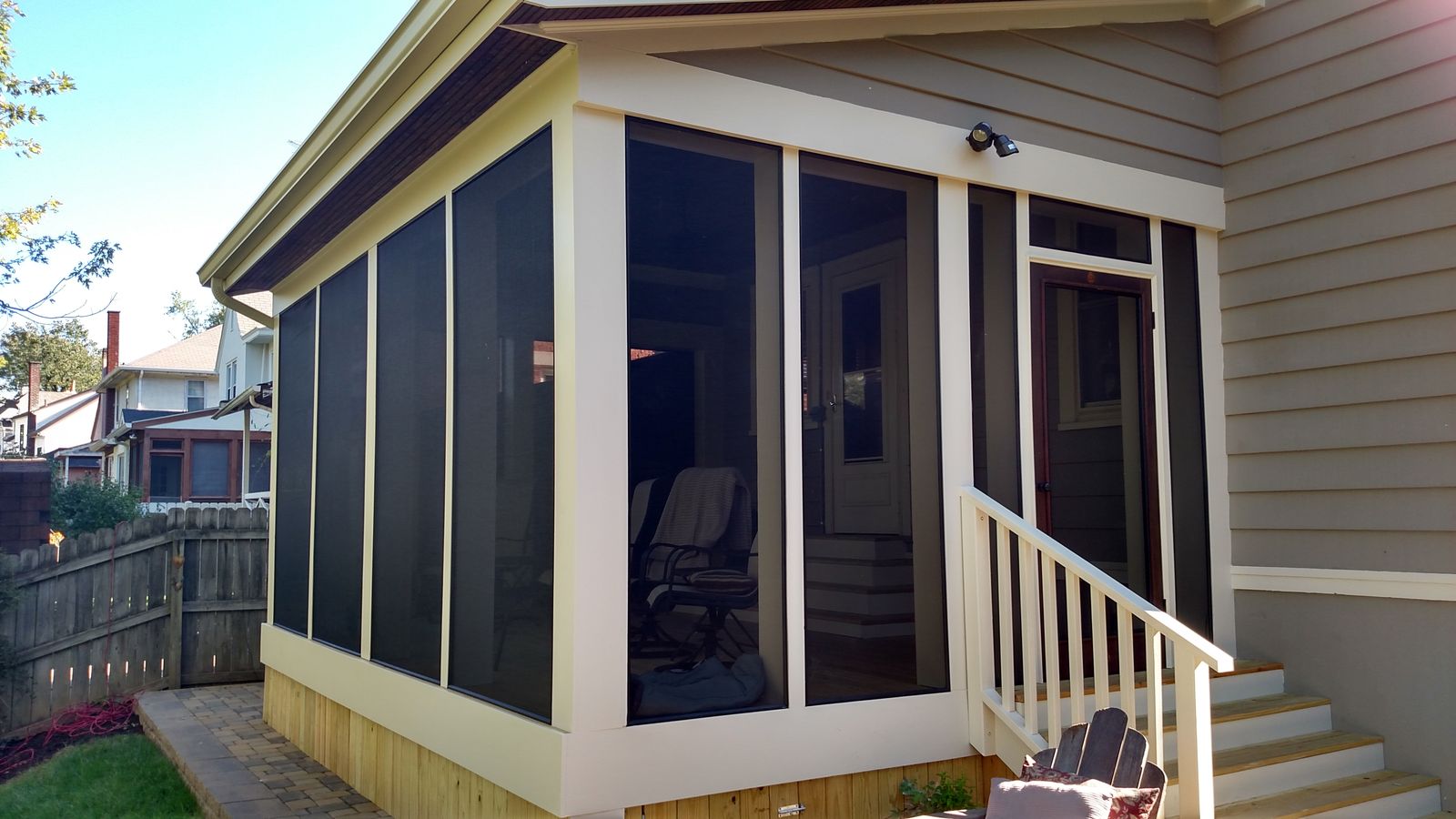 Screened porch with white trim and a stair to the yard