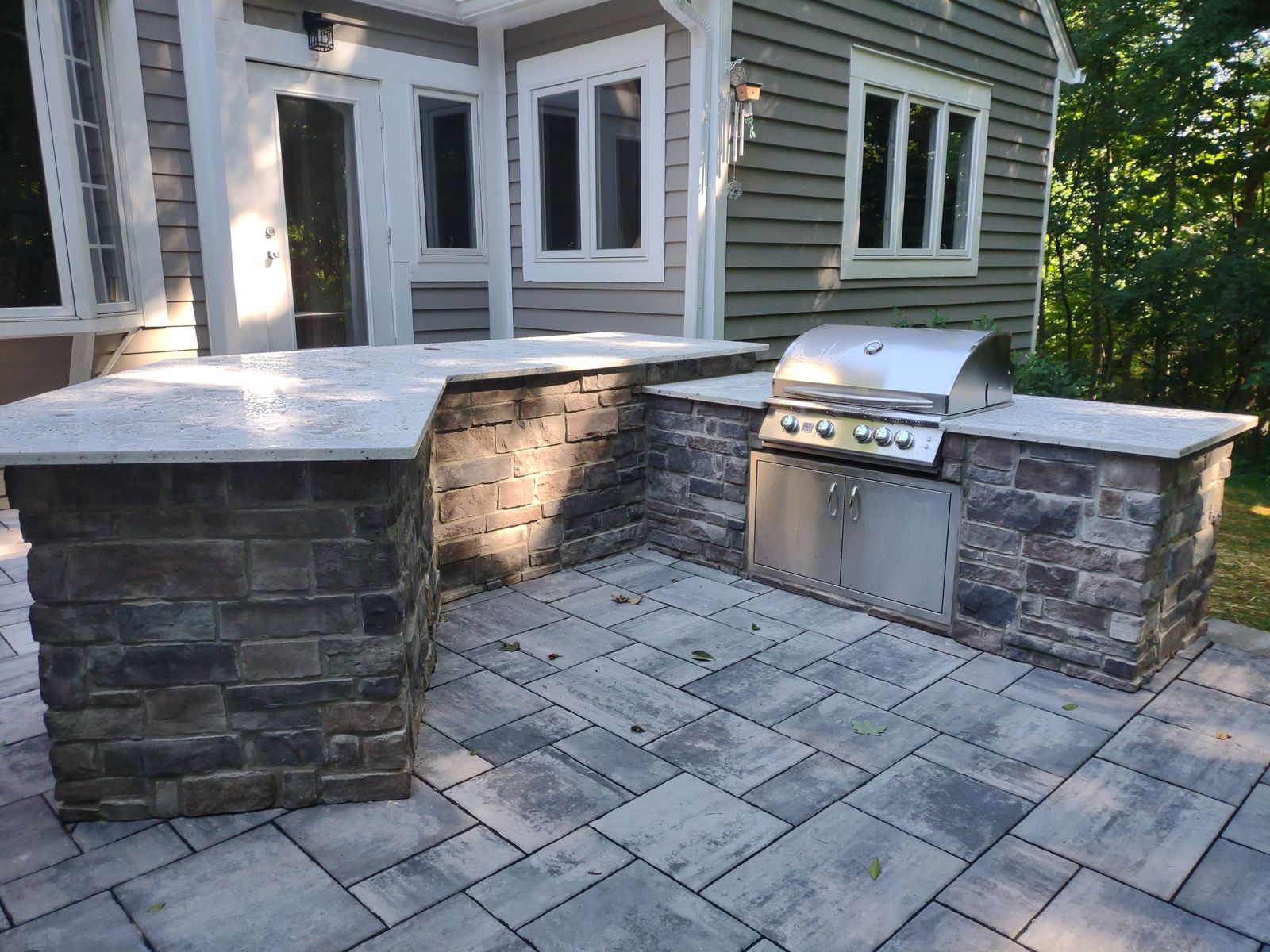 Stone-clad grill island with built-in gas grill and bar counter