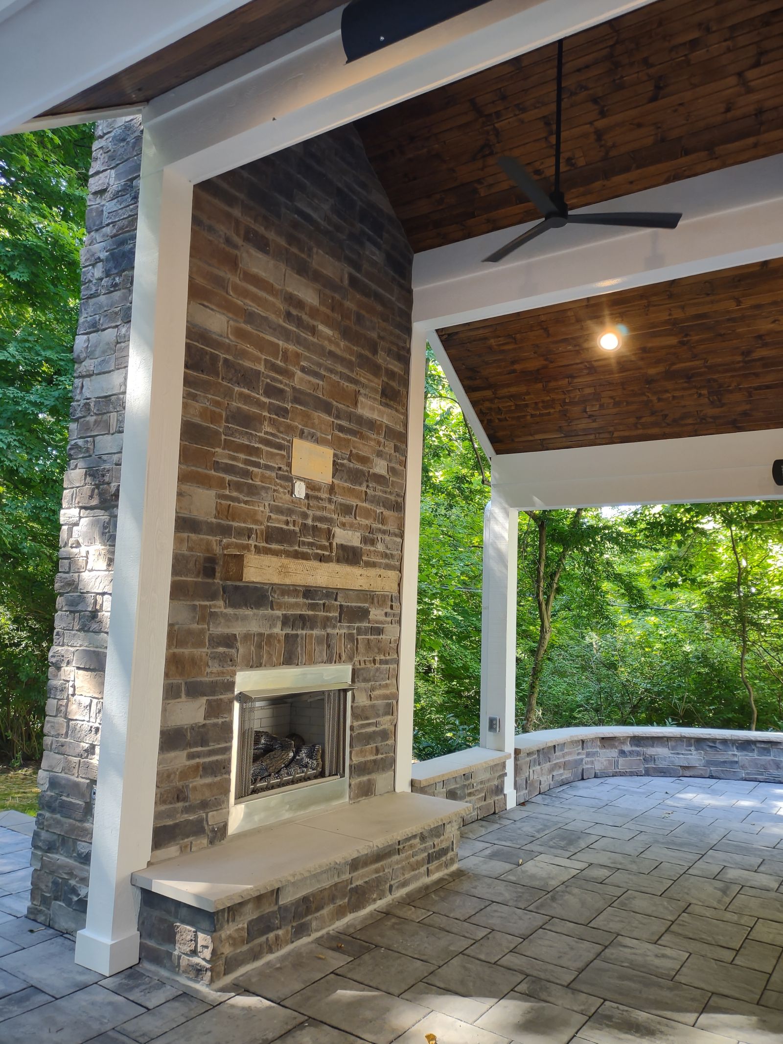 Porch interior with stone fireplace and wood ceiling detail