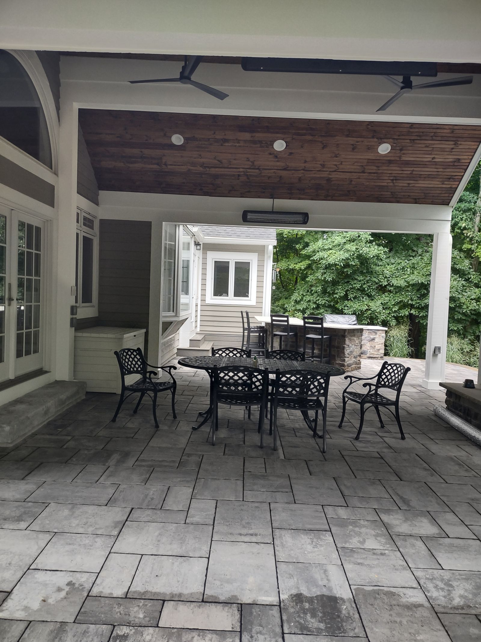 Covered patio with dining set, grill island, and infrared heaters