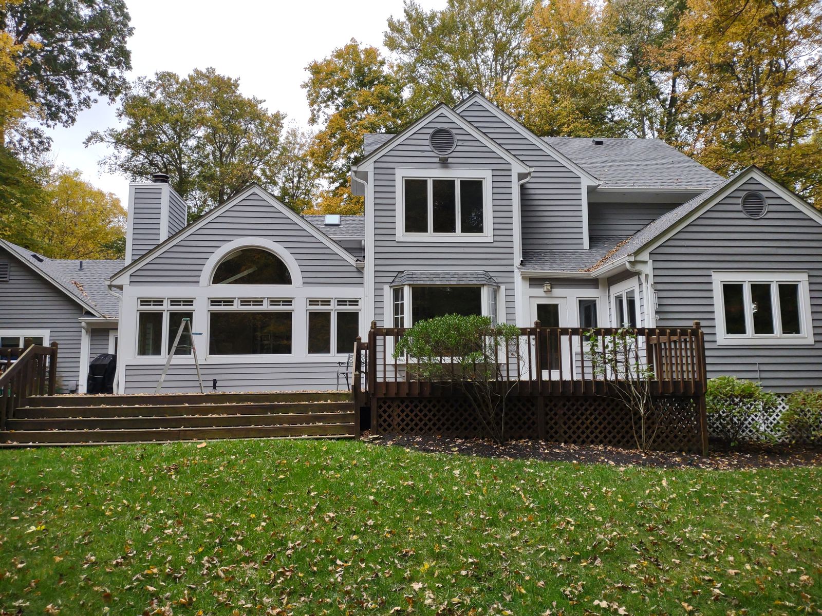 Backyard view of home with aging wood deck before renovation