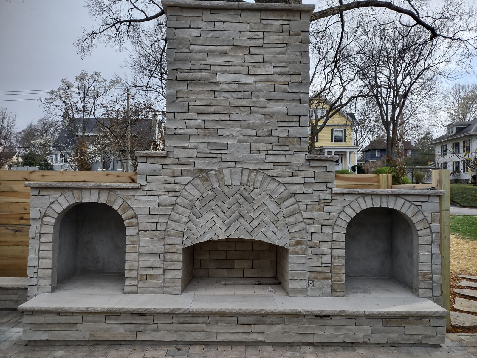 Stone outdoor fireplace with herringbone firebox