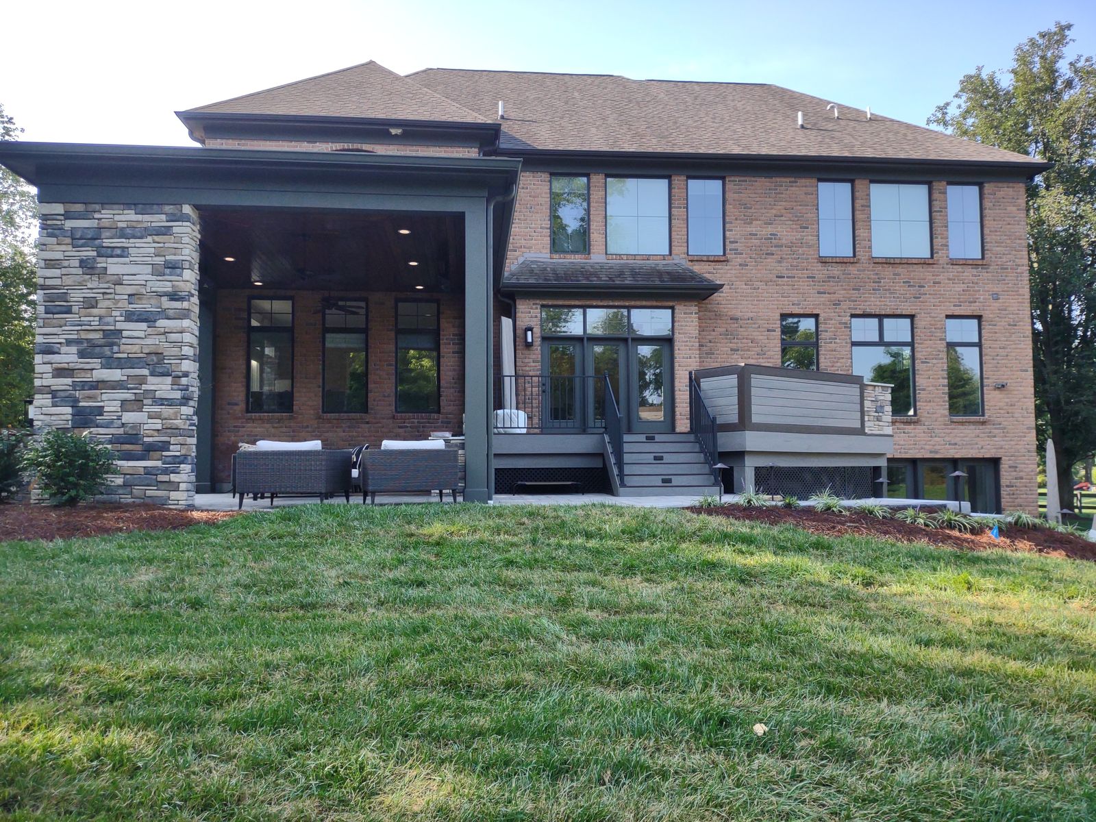 Two-story home with composite upper deck, covered lower porch, and stone fireplace
