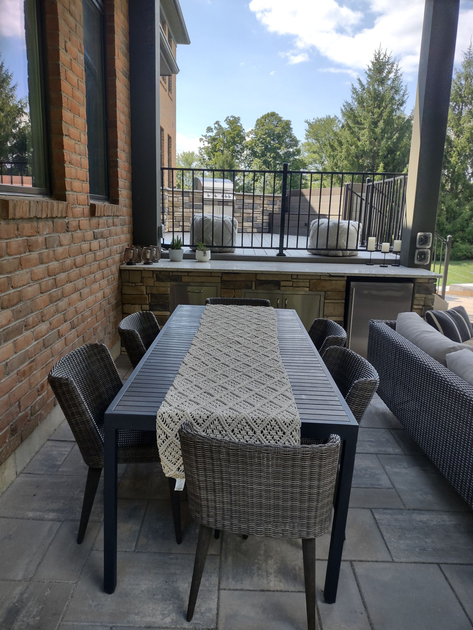 Floor-to-ceiling outdoor stone fireplace beside a paver patio