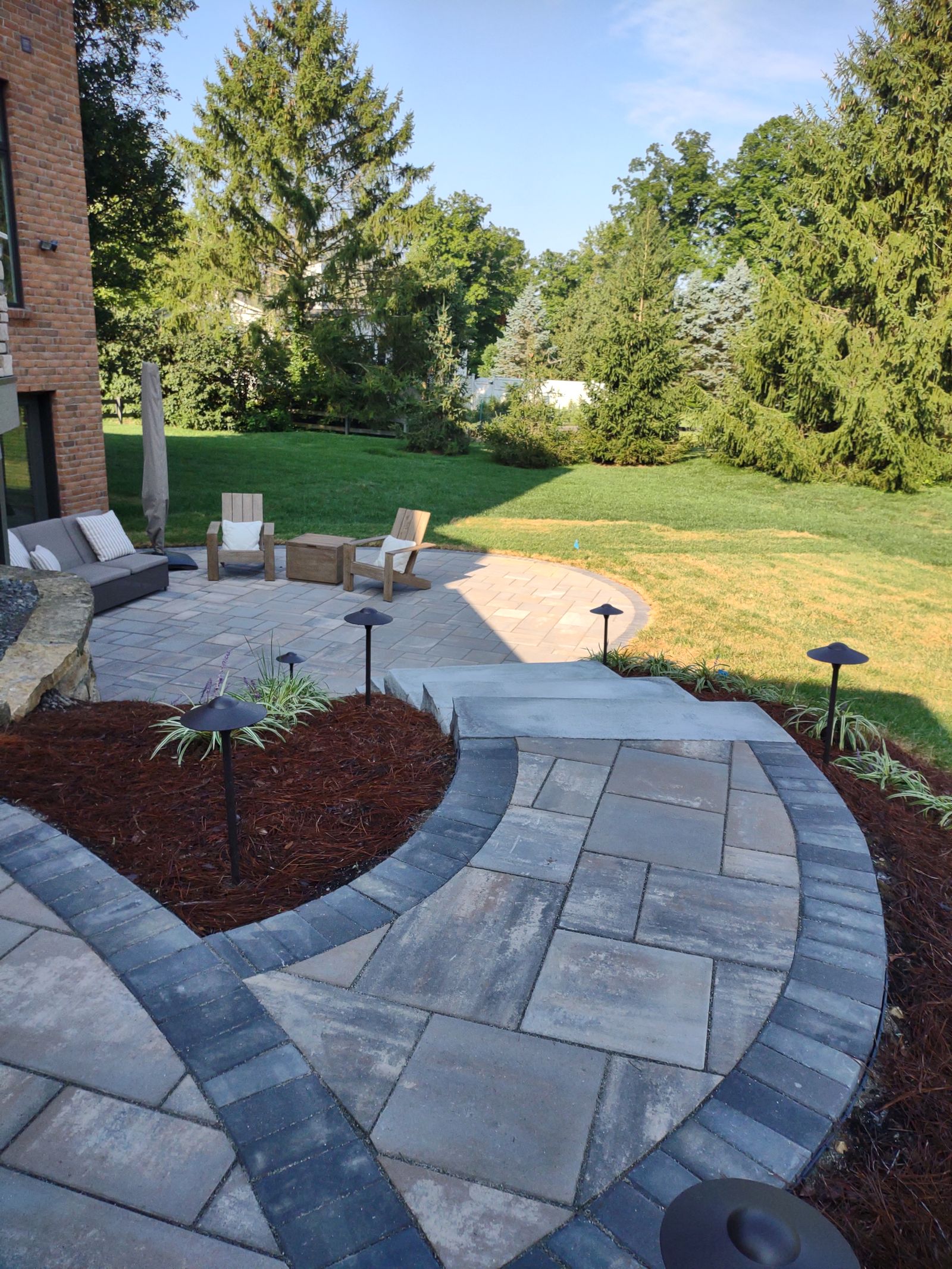 Stone fireplace and seating wall on a paver patio