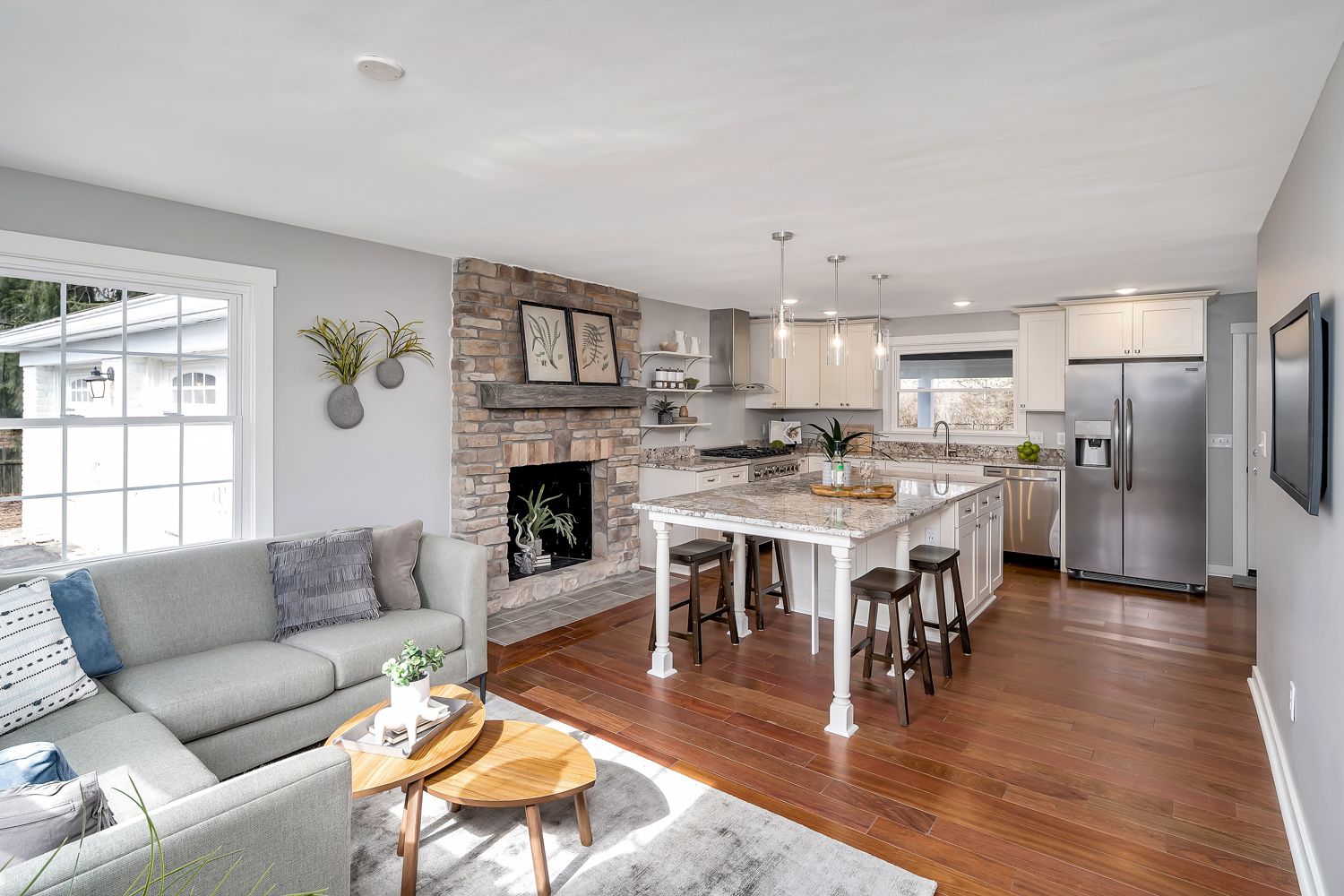 Family room with stone fireplace opening to the renovated kitchen