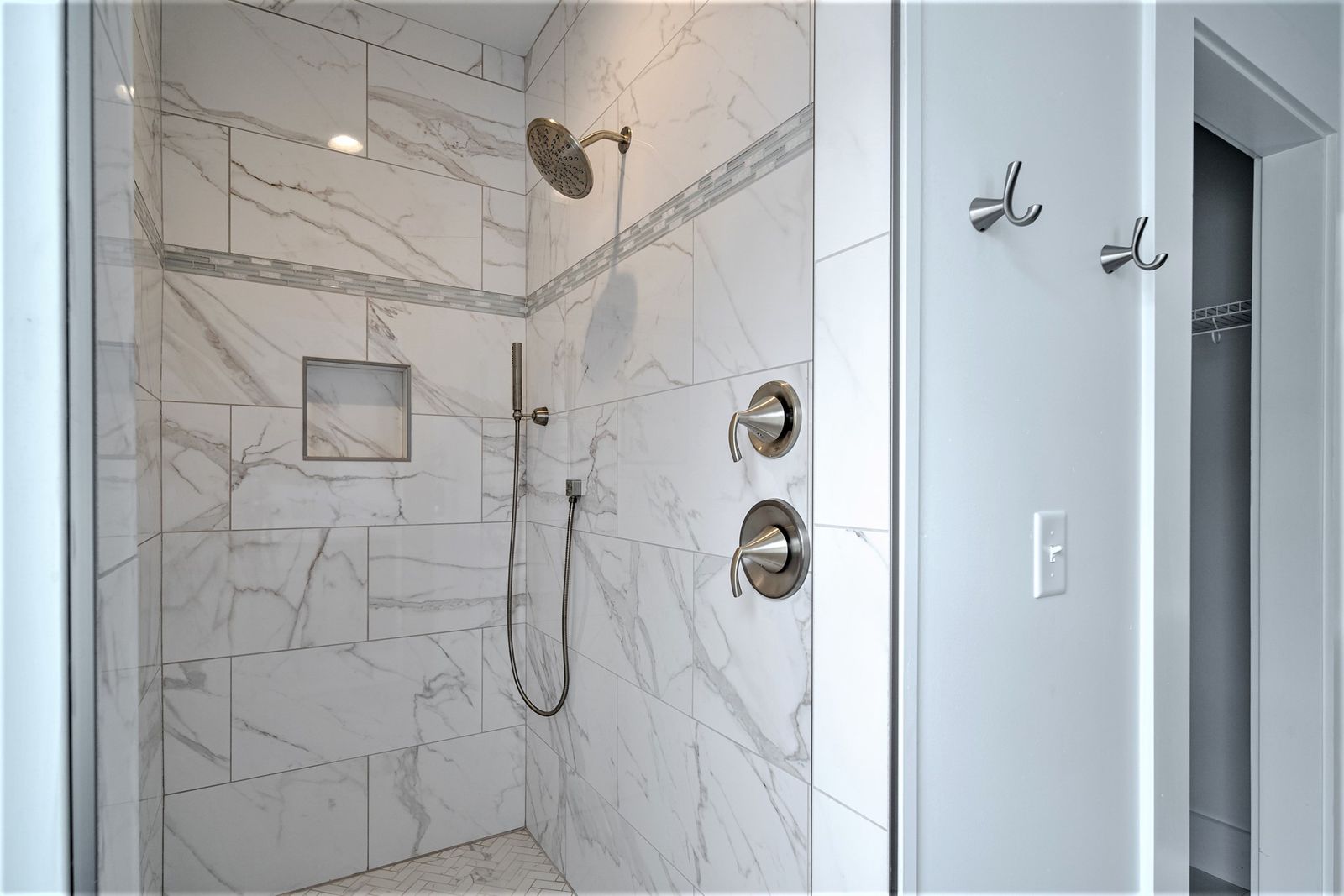 Master shower with marble-look tile and glass enclosure