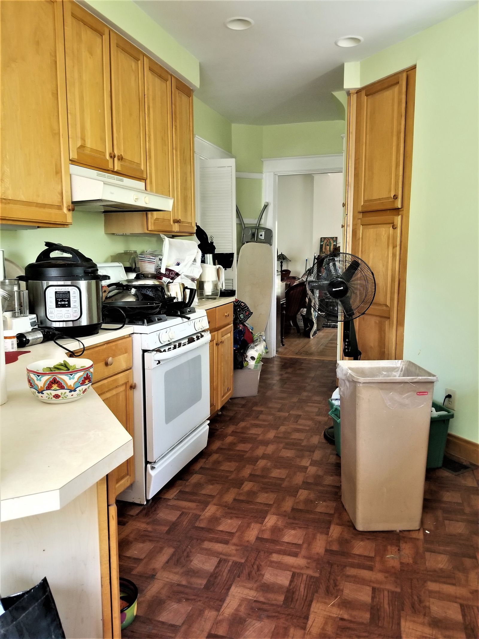 Dated galley kitchen with worn wood cabinets before renovation